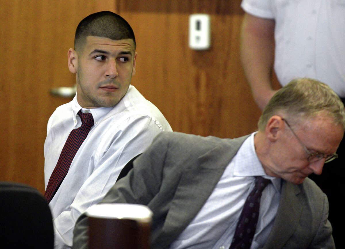 Former New England Patriots football player Aaron Hernandez, left, looks back as he sits next to his attorney Charles Rankin during a hearing in Fall River Superior Court on Sept. 30, 2014, in Fall River, Mass.