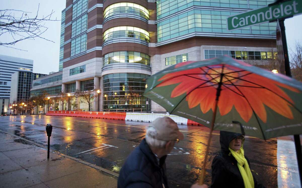 Barricades line the exterior of the Buzz Westfall Justice Center where a grand jury is expected to convene Monday to consider possible charges against the police officer who fatally shot Michael Brown as a pedestrians pass, Sunday, Nov. 23, 2014, in Clayton, Mo. (AP Photo/David Goldman)