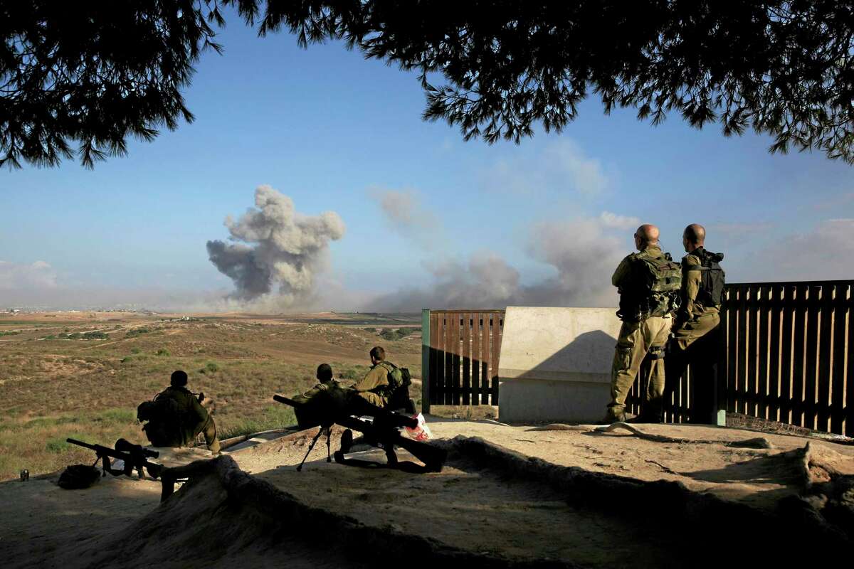 Israeli soldiers observe bombings of Gaza before a 12-hour cease-fire, seen from the border of Israel and the Gaza Strip, Saturday, July 26, 2014. Gaza residents used a 12-hour humanitarian cease-fire on Saturday to stock up on supplies and survey the devastation from nearly three weeks of fighting, as they braced for a resumption of Israel’s war on Hamas amid stalled efforts to secure a longer truce. The Israeli military said its troops “shall respond if terrorists choose to exploit” the lull to attack Israeli soldiers or civilians.