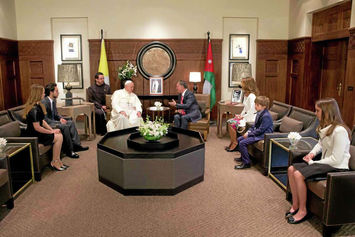 Pope Francis meets with King Abdullah II of Jordan, fourth from right, his wife Queen Rania, third from right, and their four children in Amman's Al Husseini Royal Palace, Jordan, Saturday, May 24, 2014. The pontiff is in Jordan on the first of a three day trip to the Middle East that will also take him to the West Bank and Israel. (AP Photo/Andrew Medichini, Pool)