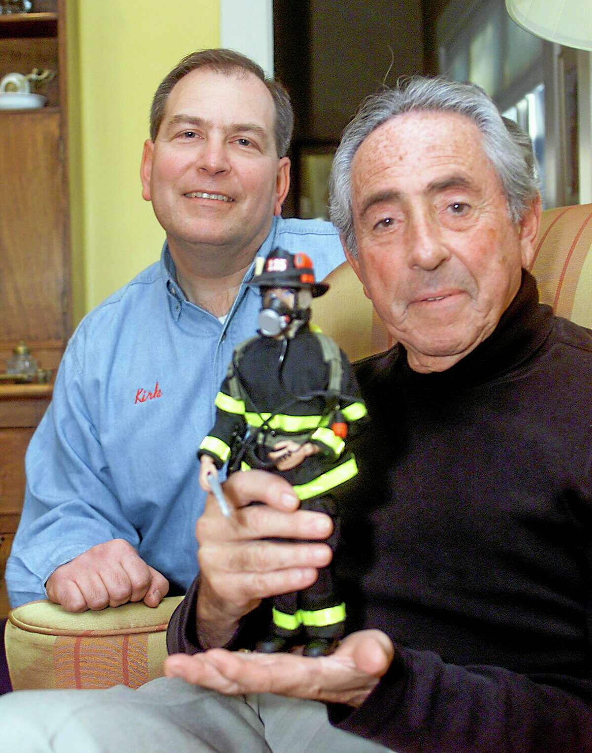 FILE - In this Dec. 7, 2001 file photo, Kirk Bozigian, left, and Don Levine, co-founders of Real Heroes Inc., show one of their collectible designs, a New York City firefighter, in Levine's home in Providence, R.I. Levine, the Hasbro executive credited as the father of G.I. Joe for developing the world's first action figure, died of cancer early Thursday, May 22, 2014, at Home & Hospice Care of Rhode Island, said his wife, Nan. He was 86. (AP Photo/Stew Milne, File)