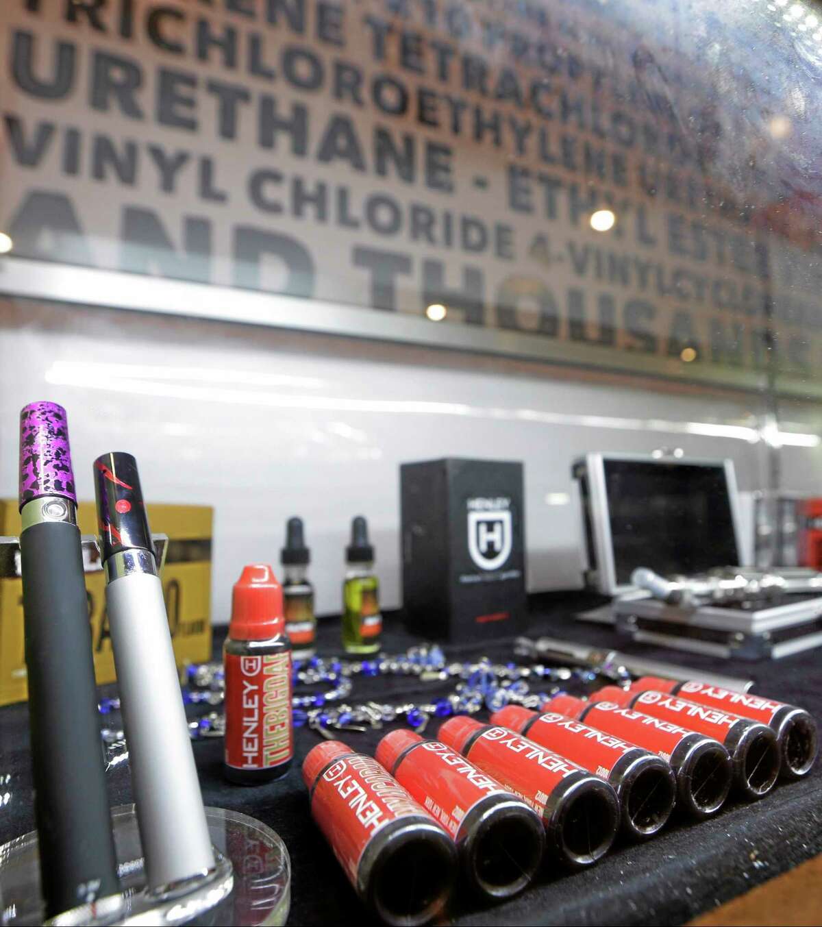 In this Feb. 20, 2014 photo, e-cigarettes and liquid nicotine solutions are displayed at the Henley Vaporium in the Soho neighborhood of New York. E-cigarettes are usually made of metal parts combined with plastic or glass and come in a variety of shapes and sizes. They heat the liquid nicotine solution, creating vapor that quickly dissipates when exhaled. (AP Photo/Frank Franklin II)