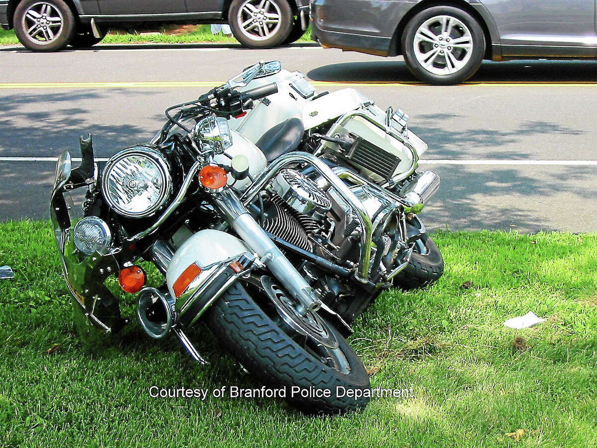 Branford Police Officer Richard Kenney escaped serious injury during an emergency call when another driver pulled out in front of his motorcycle, according to police.