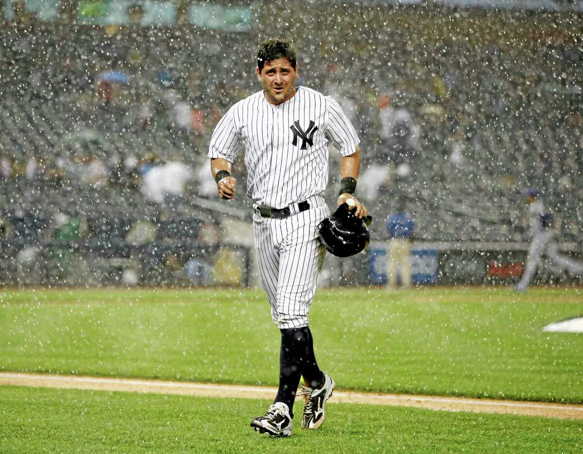The Yankees’ Francisco Cervelli, who had been on second base, runs off the field after a sudden heavy rainstorm interrupted the fifth inning of Wednesday’s game against the Texas Rangers. The Yankees won 2-1 in a game called in the botom of the fifth inning. .