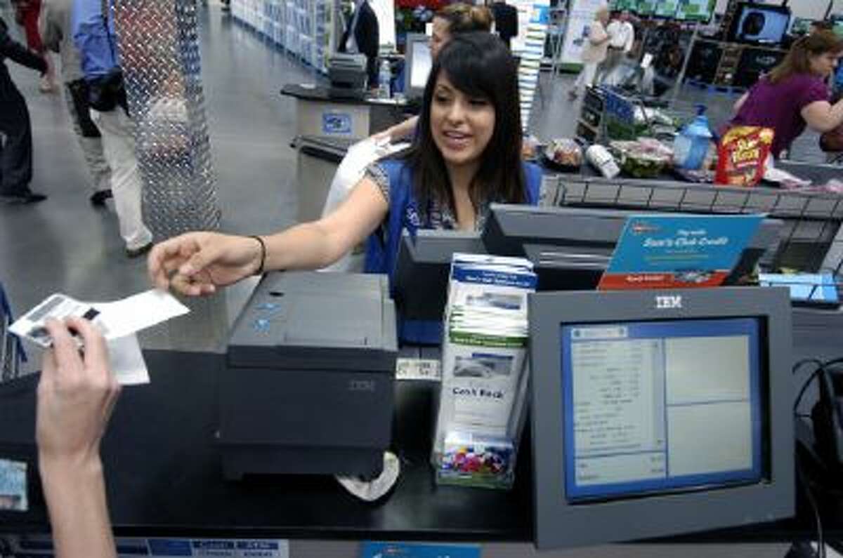 Sam's Club Inc. cashier Jessica Cornejo hands a receipt to a customer in Bentonville, Ark., on Thursday, June 4, 2009.