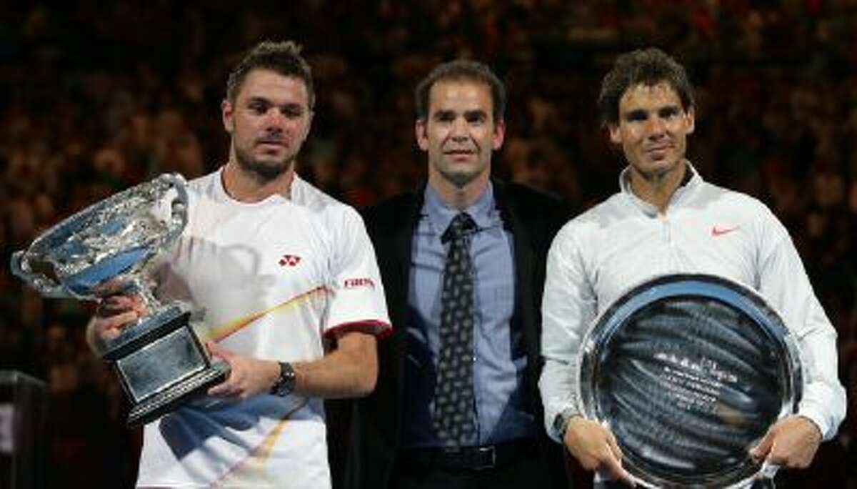 Stan Wawrinka of Switzerland, left, holds the trophy with runner-up Rafael Nadal of Spain, right, and former world No.1 Pete Sampras, after his win in their men's singles final at the Australian Open tennis championship in Melbourne, Australia, Sunday.