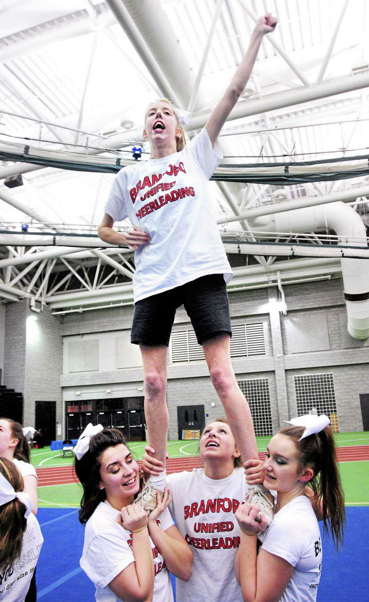 Melissa Weaving of the Branford High School Unified cheerleading team is hoisted into the air during practice before their performance at the CIAC Cheerleading Championships at the Floyd Little Athletic Center in New Haven earlier this month.