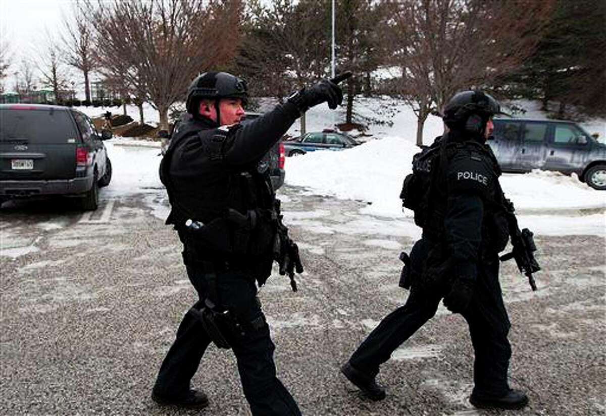 Police move in from a parking lot to the Mall in Columbia after reports of a multiple shooting, Saturday Jan. 25, 2014 Howard County, Md. Police in Maryland say three people died Saturday in a shooting at a mall in suburban Baltimore, including the presumed gunman.