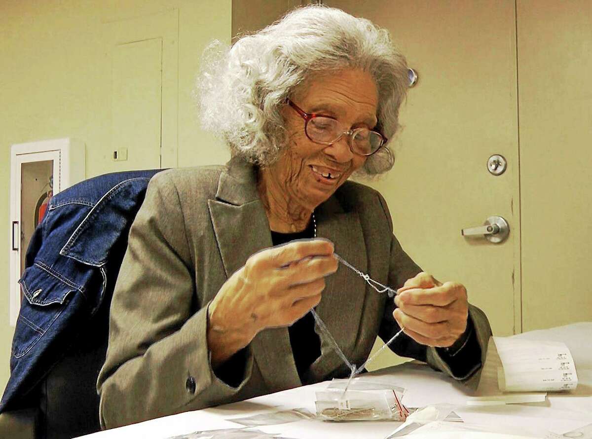 In an image from video, Frances Moore, 93, puts a tag on a necklace at Bromberg & Co. jewelry in Mountain Brook, Ala.