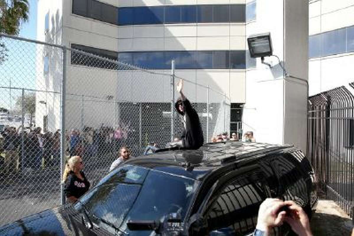 Justin Bieber waves after exiting from the Turner Guilford Knight Correctional Center on January 23, 2014 in Miami, Florida. Justin Bieber was charged with drunken driving, resisting arrest and driving without a valid license after Miami Beach police found the pop star street racing Thursday morning.