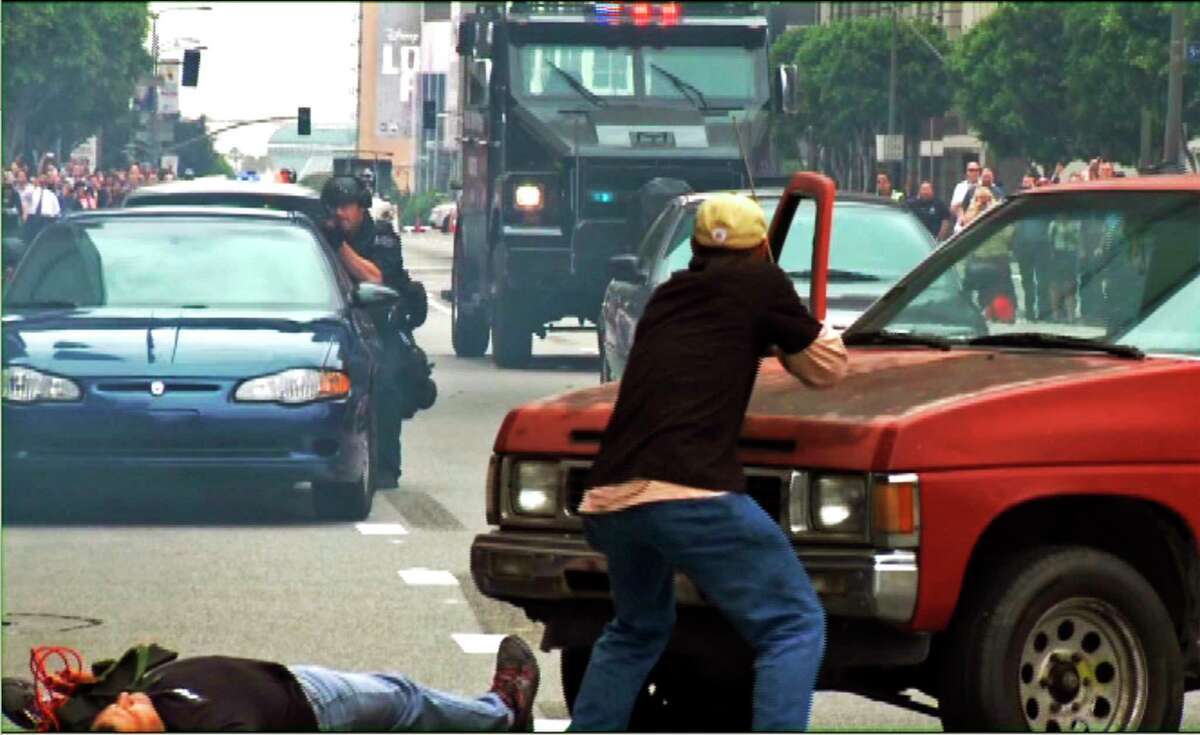 In this July 6, 2013 still frame from a video produced by the Los Angeles Police Department, as police take part in a counterterrorism drill. A Lenco Bearcat, an armored vehicle purchased by the LAPD from a Massachusetts firm that builds them for a variety of military and police uses, stands at the rear.
