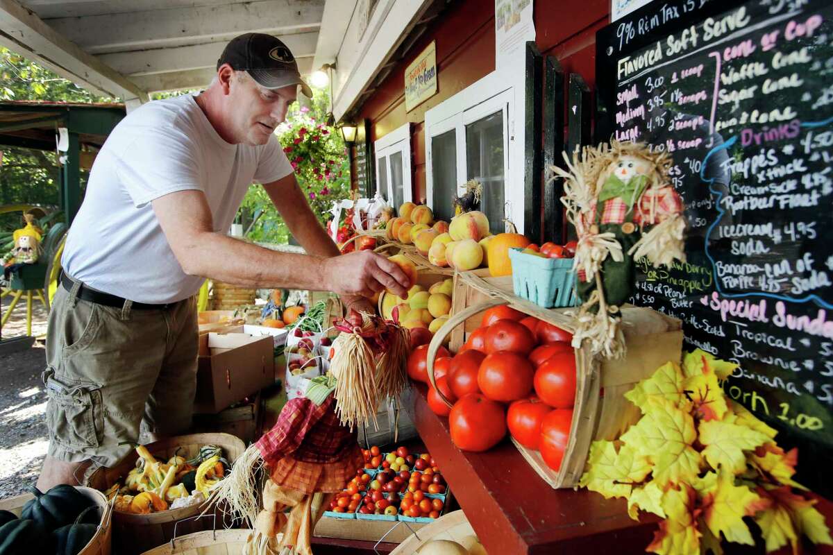 Roland Spencer sets up his farm stand in Weare, N.H. The stand is roughly 30 yards from the stand of trees where the car driven by an unarmed 35-year-old Alex Cora DeJesus crashed after he was fatally shot during a drug sting gone bad last year. The town hired a new police chief, John Velleca, less than a year ago to clean up a department mired in federal lawsuits. Now Velleca is on paid administrative leave after becoming the target of a domestic violence restraining order involving a subordinate.