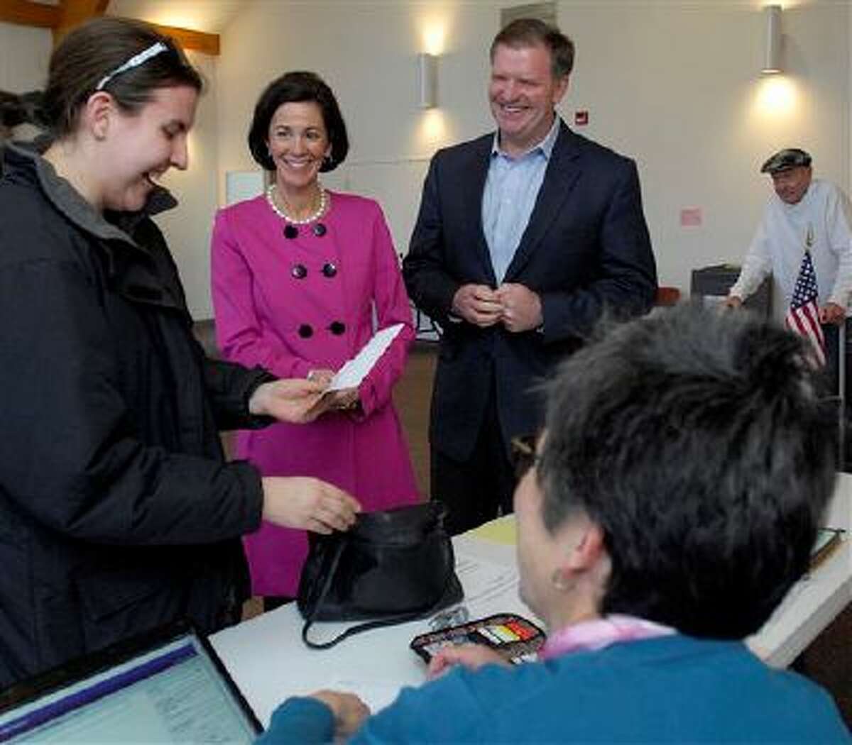 State Senator Bill Brady and his wife Nancy talk with fellow voter Katie Graehling of Bloomington while checking in with election judge Karen Fleming for their ballots as they prepare to vote in the 2014 primary election Tuesday. (AP Photo/The Pantagraph, Lori Ann Cook-Neisler)