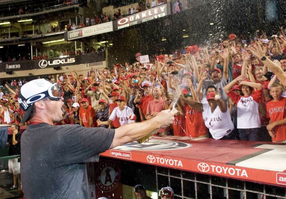 Los Angeles Angels third baseman David Freese sprays the crowd with champagne after the Halos clinched the American League West on Wednesday at Angel Stadium.