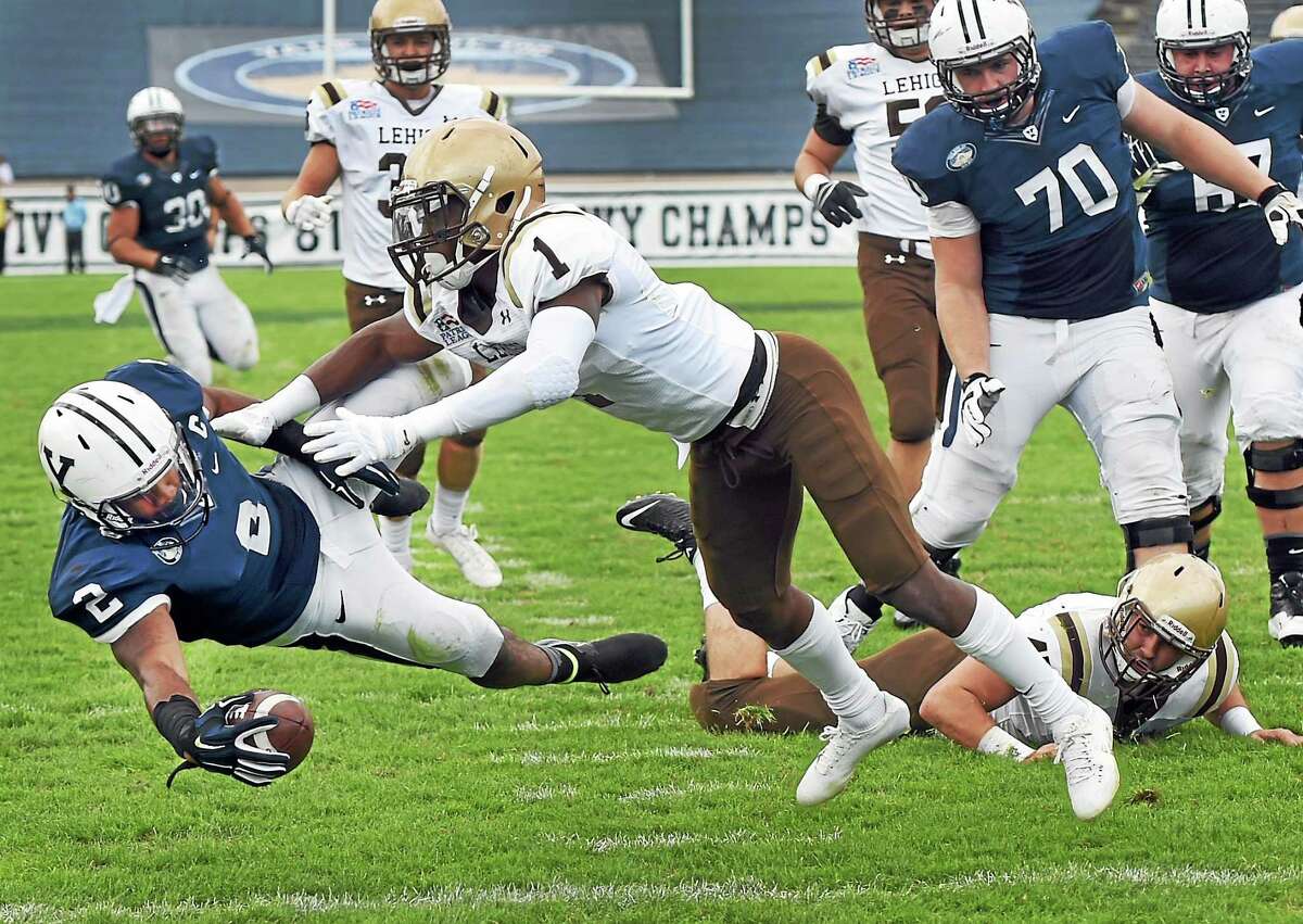 Yale’s Deon Randall scores a touchdown after getting by Lehigh’s Oliver Rigaud during the first quarter of the Bulldogs’ 54-43 win on Saturday at Yale Bowl.