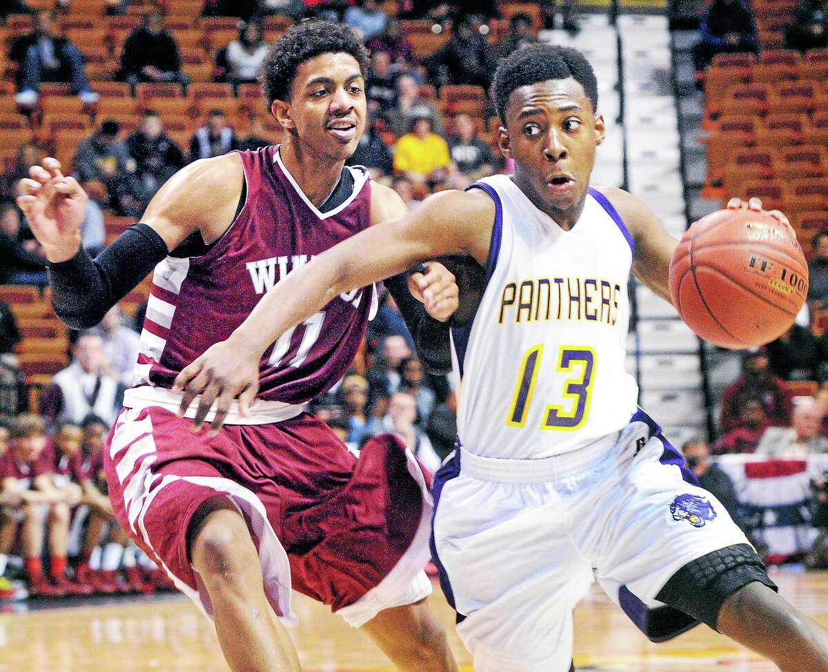 (Arnold Gold-New Haven Register) Aaron McHenry (left) of Windsor pressures Amos Ford of Career in the second half of the Class L Boys Basketball Final at the Mohegan Sun on 3/23/2014.