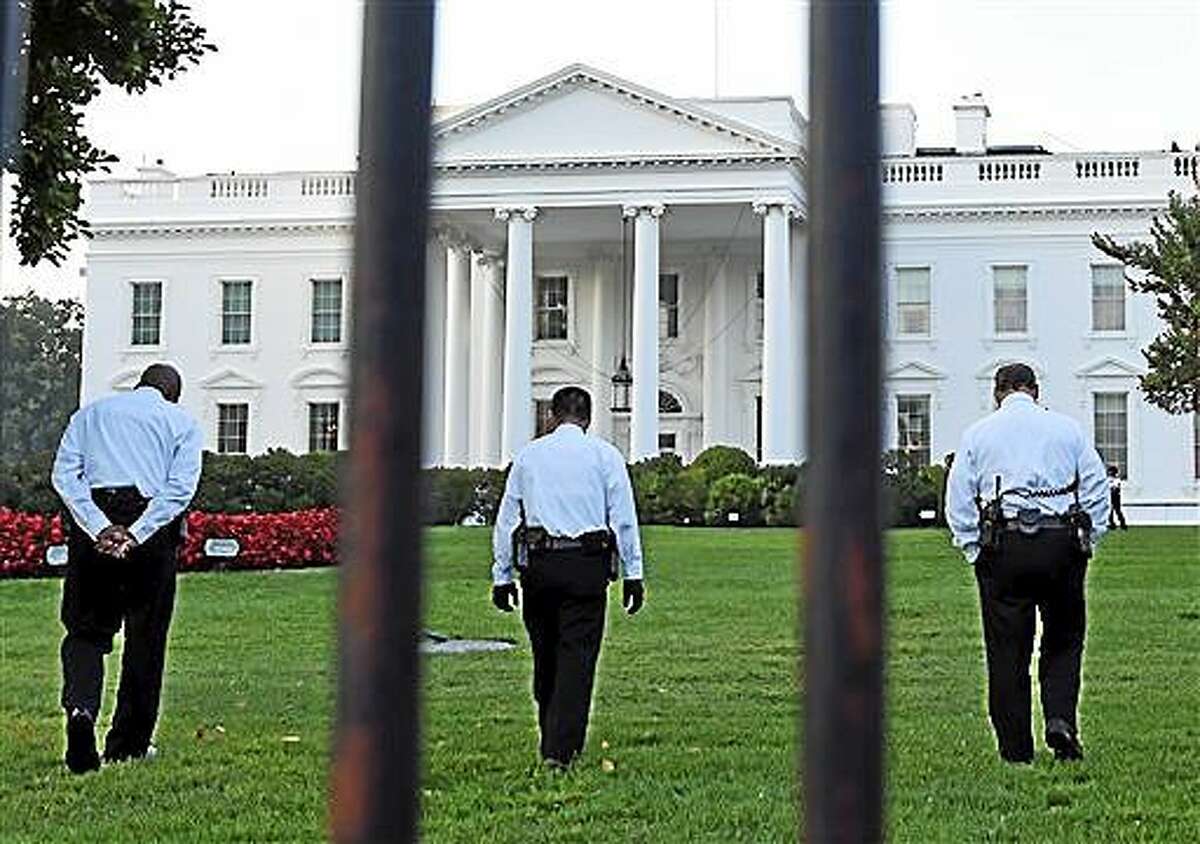 Uniformed Secret Service officers walk along the lawn on the North side of the White House in Washington, Saturday, Sept. 20, 2014. The Secret Service is coming under renewed scrutiny after a man scaled the White House fence and made it all the way through the front door before he was apprehended. (AP Photo/Susan Walsh)
