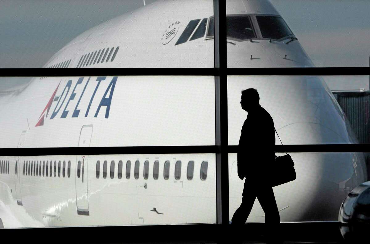 FILE - In this file photo made Jan. 21, 2010, a passenger walks past a Delta Airlines 747 aircraft in McNamara Terminal at Detroit Metropolitan Wayne County Airport in Romulus, Mich. Delta Air Lines on Tuesday, July 22, 2014 canceled all flights to Israel until further notice, citing reports that a rocket landed near Tel Aviv's Ben Gurion Airport. (AP Photo/Paul Sancya, File)