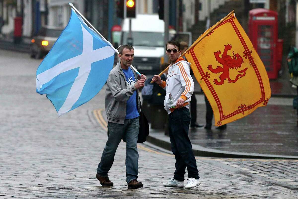 Supporters of the Yes campaign for the Scottish independence referendum stand Friday on the Royal Mile in Edinburgh, Scotland. Scottish voters have rejected independence and decided that Scotland will remain part of the United Kingdom. The result announced early Friday was the one favored by Britain’s political leaders, who had campaigned hard in recent weeks to convince Scottish voters to stay. It dashed many Scots’ hopes of breaking free and building their own nation.