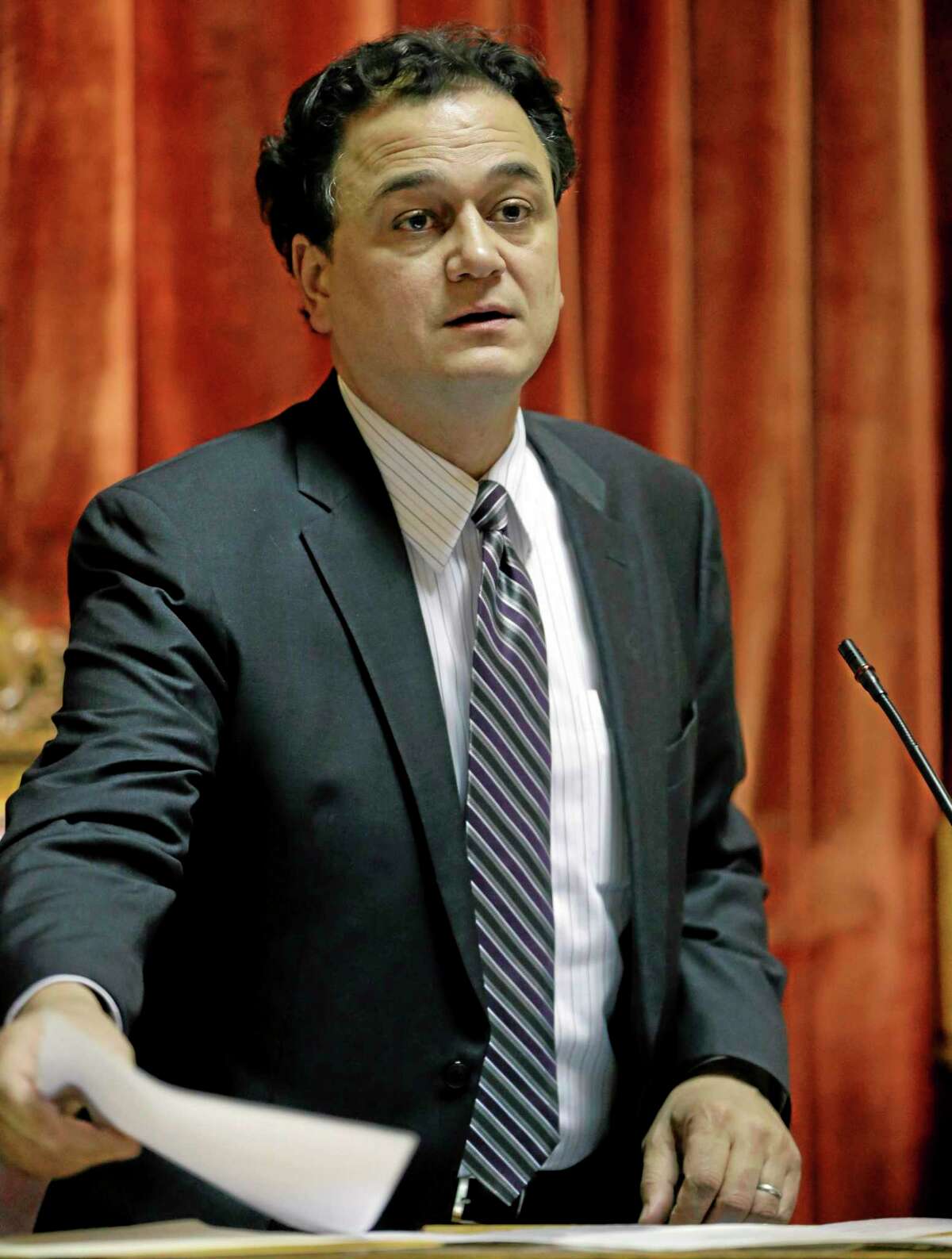 In this Jan. 24, 2013, photo, Rhode Island Speaker of the House Gordon Fox places papers on the rostrum moments before calling the House into session in Providence, R.I.