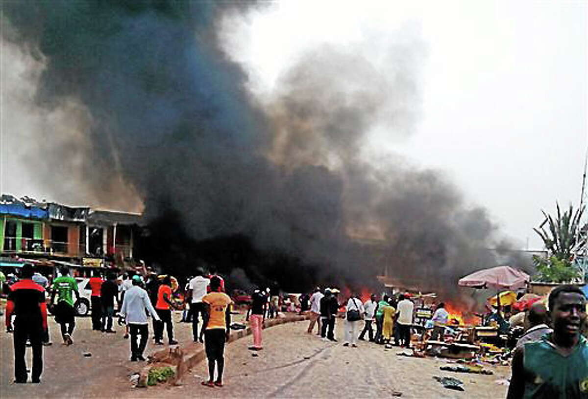Smoke rises after a bomb blast at a bus terminal in Jos, Nigeria, Tuesday, May 20, 2014. Two explosions ripped through a bustling bus terminal and market frequented by thousands of people in Nigeria's central city of Jos on Tuesday afternoon, and police said there are an unknown number of casualties. The blasts could be heard miles away and clouds of black smoke rose above the city as firefighters and rescue workers struggled to reach the area as thousands of people fled. (AP Photo/Stefanos Foundation)