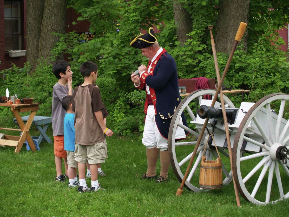 At last year’s encampment, yesterday meets today near a Revolutionary War cannon.