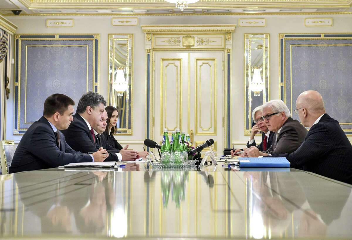 Ukrainian President Petro Poroshenko, second left, talks with German Foreign Minister Frank-Walter Steinmeier, second right, in Kiev, Ukraine. Tuesday, Nov. 18, 2014.