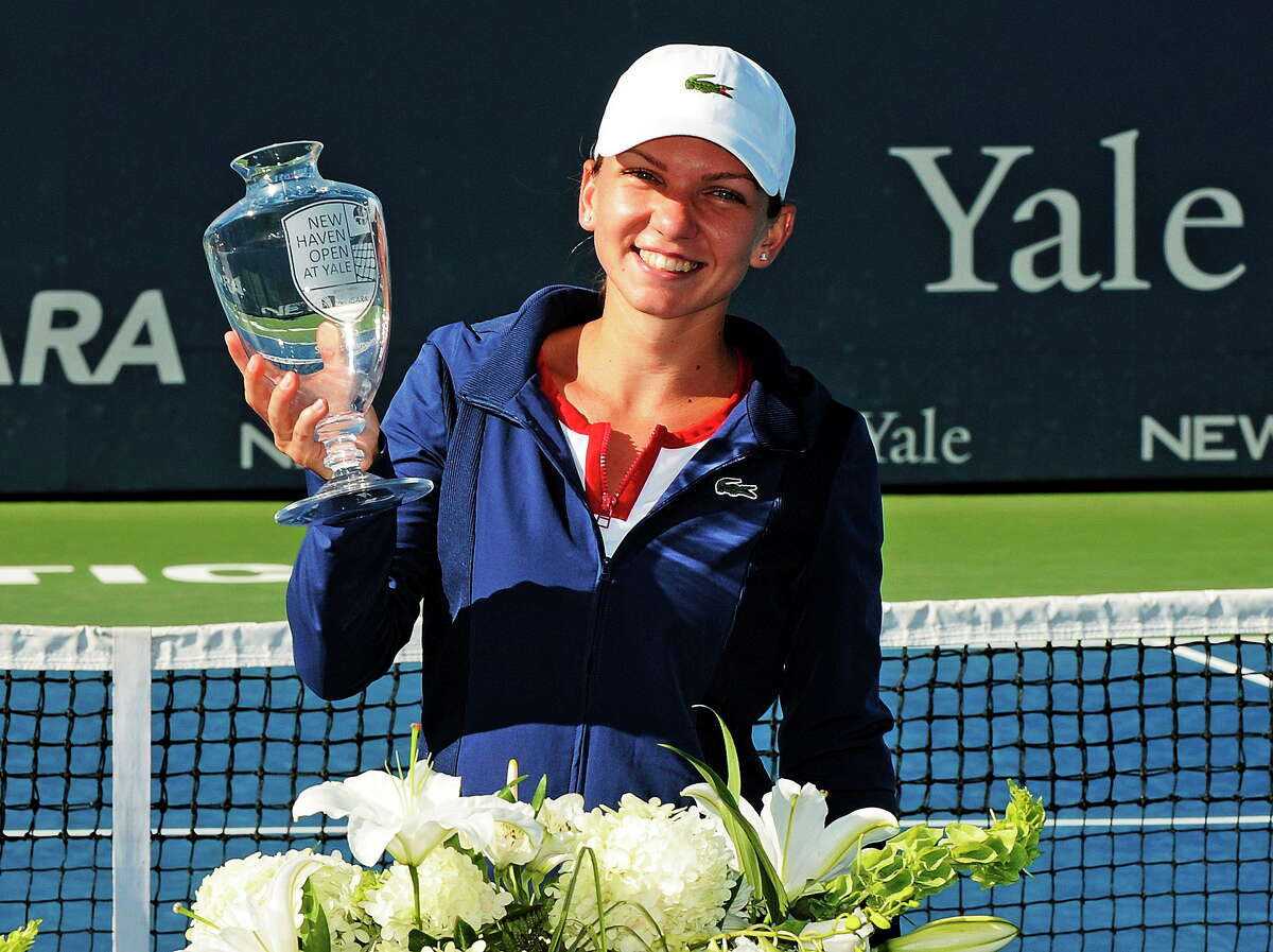 Simona Halep, of Romania, holds the trophy after her 6-2, 6-2, victory over Petra Kvitova, of the Czech Republic, in the final of the New Haven Open tennis tournament in New Haven, Conn., on Saturday, Aug. 24, 2013. (AP Photo/Fred Beckham)