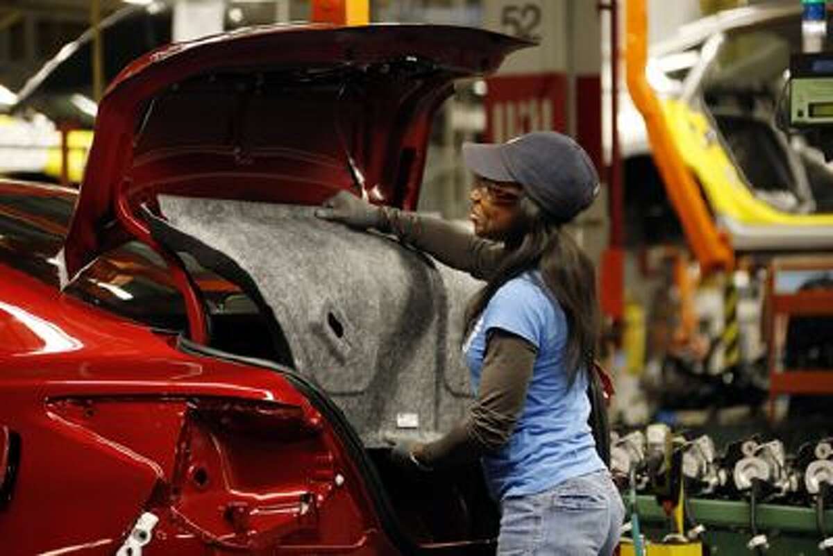 A Nissan employee tacks in the trunk lining into an new Altima sedan chassis Thursday, Jan. 10, 2013 at its Canton, Miss., manufacturing plant.