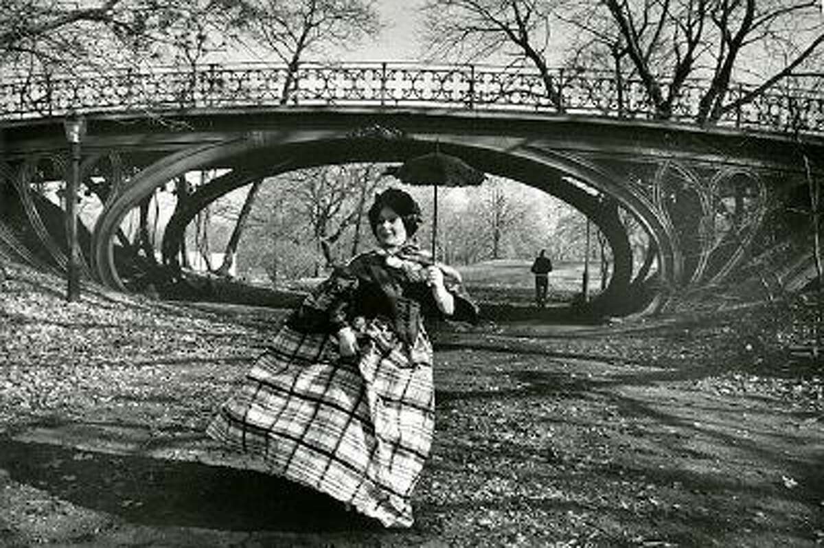 This photo provided by the New-York Historical Society shows the photographer Bill Cunningham's muse Editta Sherman in front of the Gothic bridge in Central Park, which was designed in 1860, in New York. The photo is one of 88 prints from Bill Cunninghams 1976-1978 project, Facades, featured in an exhibition at the New-York Historical Society, running through June 15, 2014. The images are a whimsical photo essay in which Cunningham posed models in period costumes against famous New York City historic sites of the same vintage. (AP Photo/New-York Historical Society, Gift of Bill Cunningham)