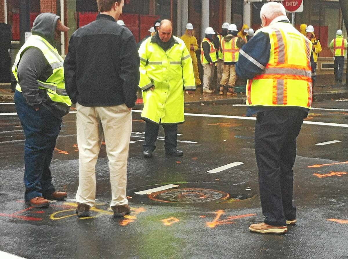 (Wes Duplantier -- New Haven Register) The intersection of Crown and College streets in New Haven was shut down late Monday morning after a sinkhole was found. The sinkhole did not collapse but a dip in the pavement was clearly visible as was cracking in the asphalt.