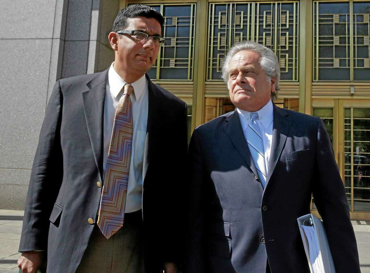Conservative scholar and filmmaker Dinesh D'Souza, left, accompanied by his lawyer Benjamin Brafman leave federal court, in New York, Tuesday, May 20, 2014. D'Souza has pleaded guilty in New York federal court to making illegal campaign contributions. He admitted getting two close associates to make $10,000 contributions to Wendy Long. She was a candidate who lost the New York Senate race in 2012 to the Democratic incumbent. His plea agreement calls for a sentence of 10 to 16 months in prison. He'll be sentenced on Sept. 23. (AP Photo/Richard Drew)