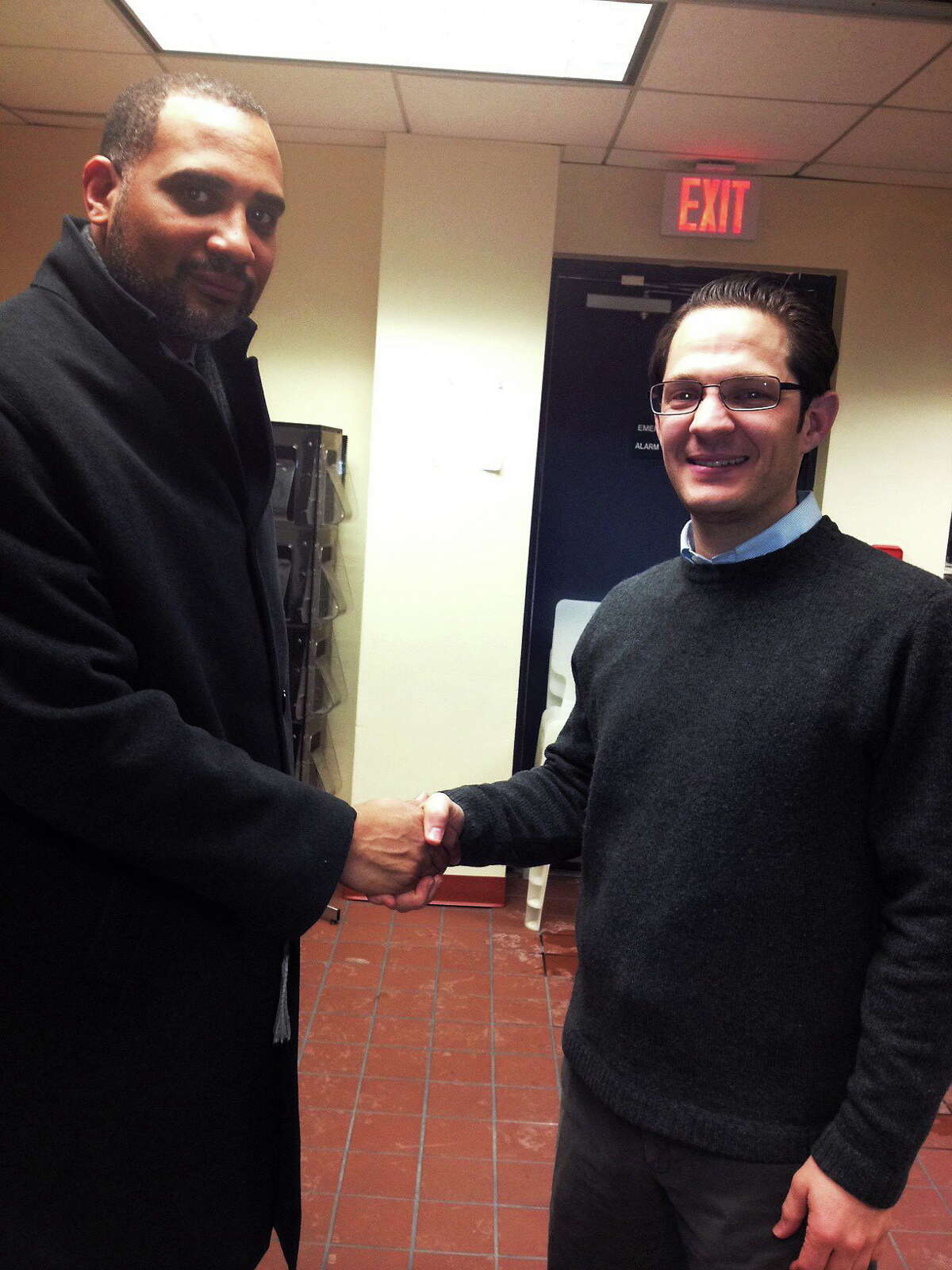 LCI director Erik Johnson, left, and Navarino Capital Management owner Justin Goldberg shake on the Dwight Gardens deal.