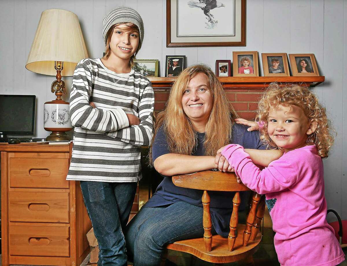 Trish Kallman and her two younger children, Jesse, 13 and three-year-old Julie in their Milford home. Kallman and her husband Bill also have a 15-year-old daughter, Jennifer and are struggling to make ends meet.