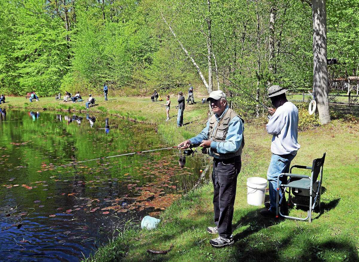 (Peter Casolino-New Haven Register) Vietnam veterans, Ron St. John of Hamden, front, and Kingsley Whyte of West Haven fish at the Guilford Sportsmen's Association pond in Guilford during the annual 'Take a Vet Fishing' day. Both are Army veterans. 5/17/14 pcasolino@newhavenregister.com