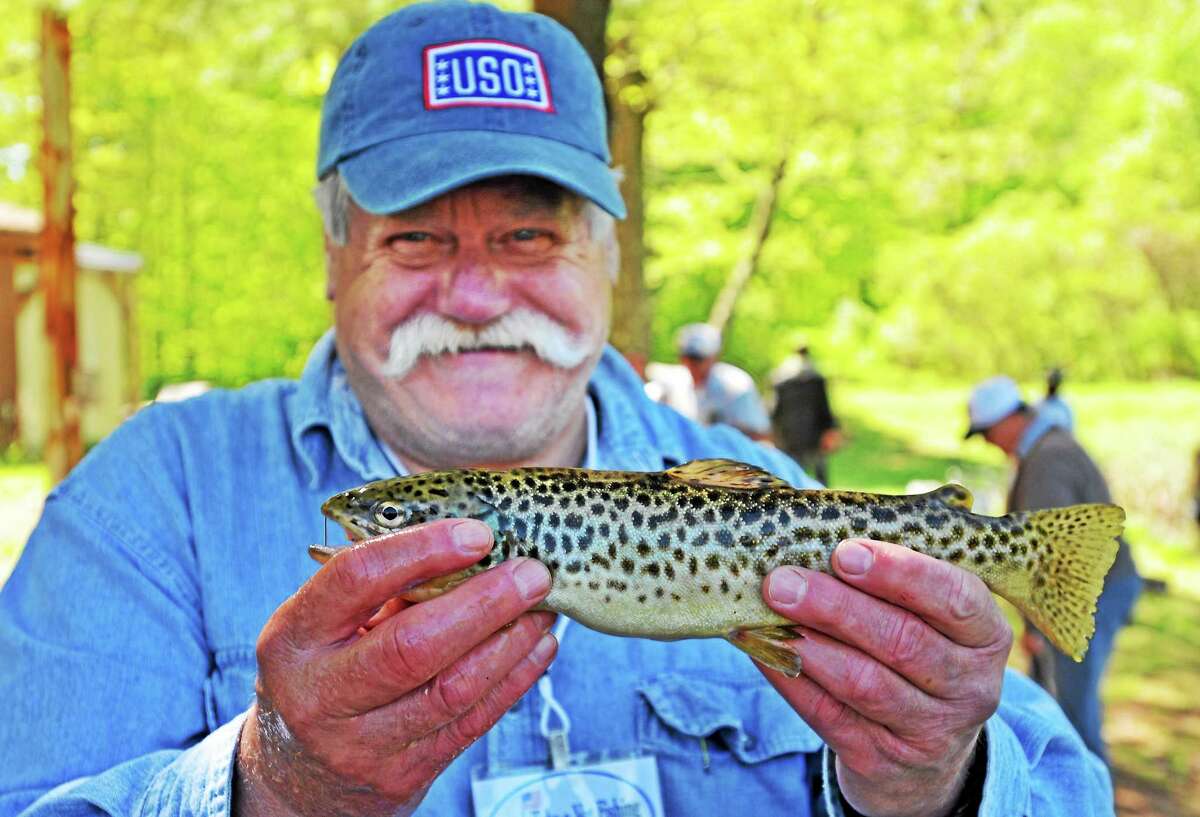 (Peter Casolino-New Haven Register) Vietnam army veteran Barry Braman shows off a trout he reeled in at the Guilford Sportsmen's Association pond in Guilford during the annual 'Take a Vet Fishing' day. Braman is from Hamden. 5/17/14 pcasolino@newhavenregister.com