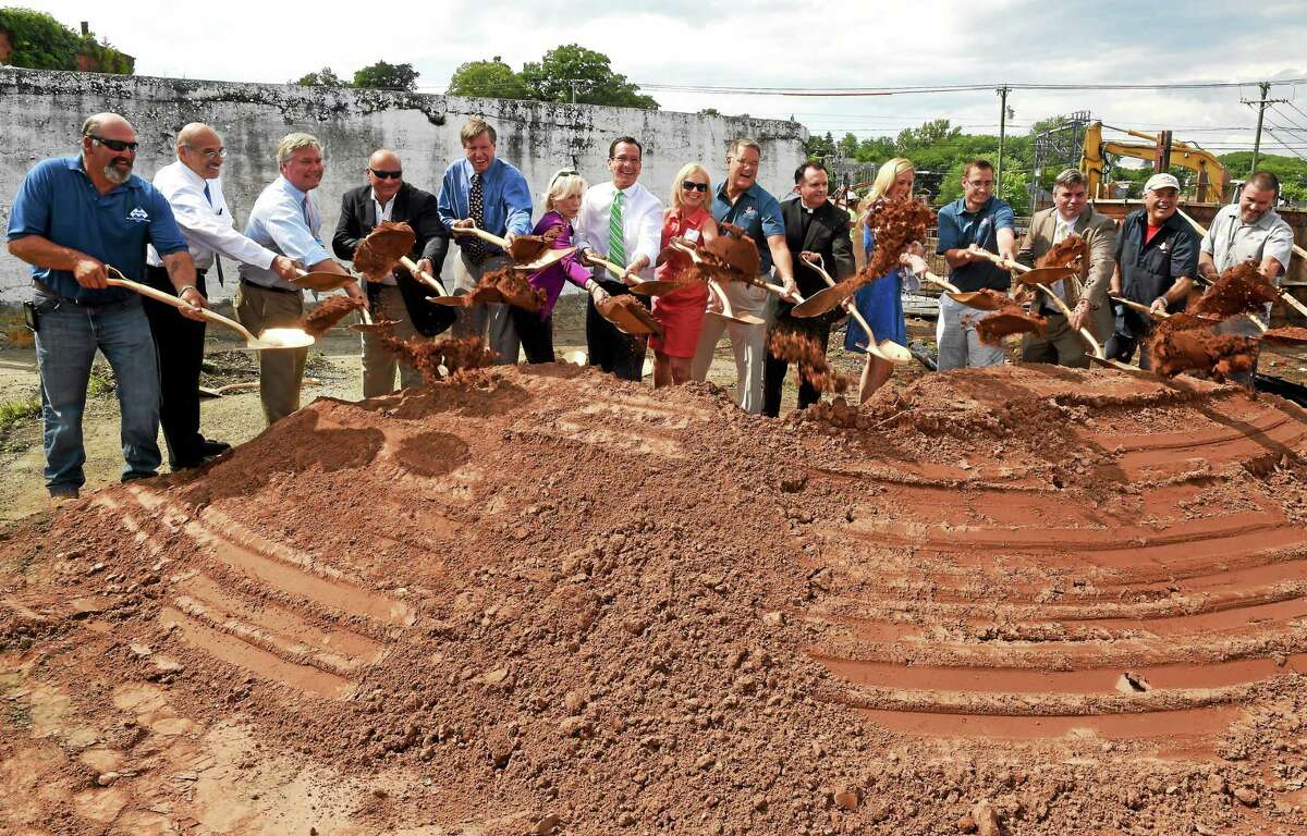 Stony Creek Brewery founders Peggy and Ed Crowley Sr., eight and ninth from left, along with brewery employees, construction representatives, politicians, dignitaries and friends take part in a ground-breaking ceremony Thursday at the future site of the Stony Creek Brewery at 5 Indian Neck Ave. in Branford.