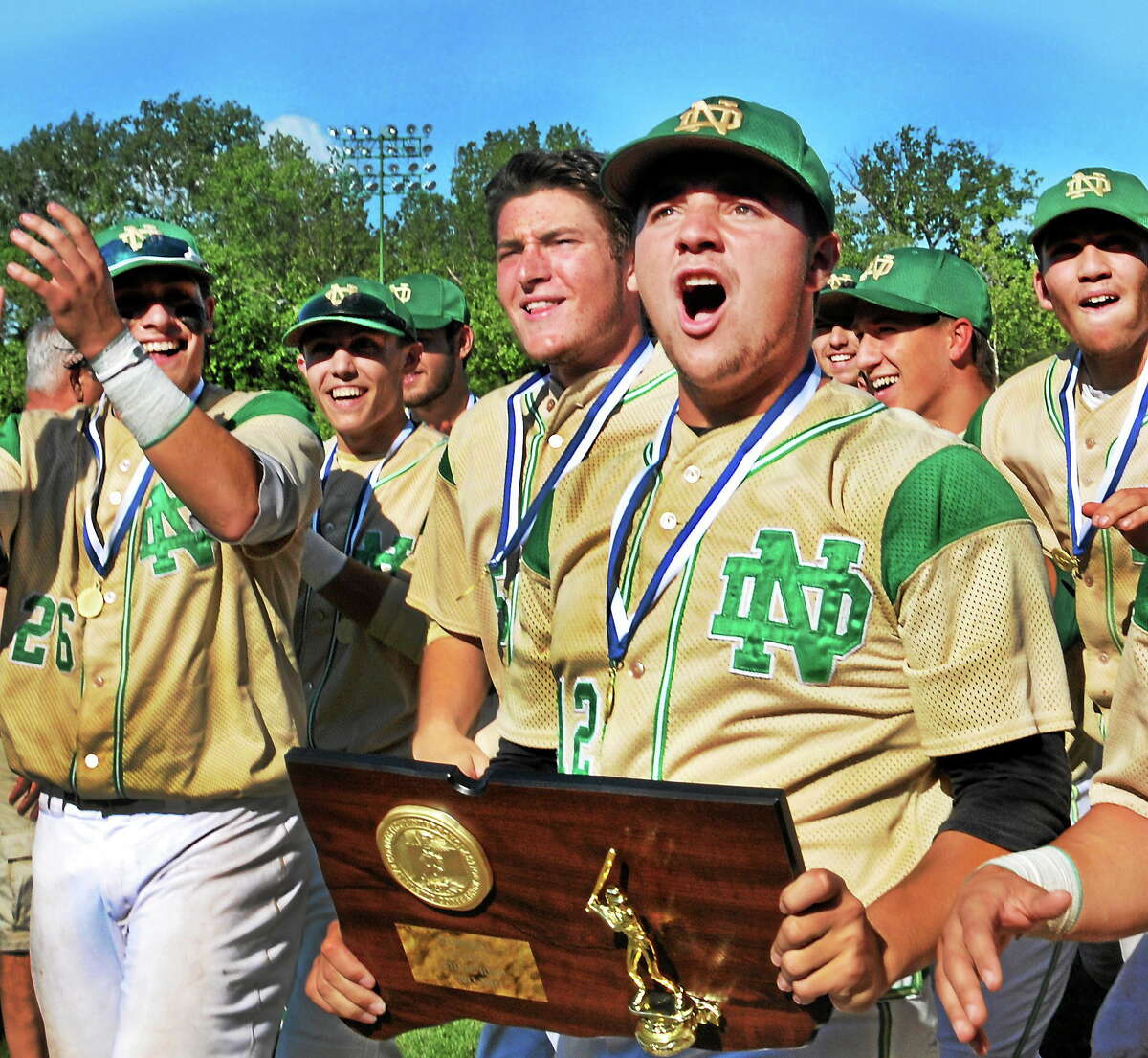 Notre Dame-West Haven pitcher John Amendola holds the Class L state championship plaque after the Green Knights defeated Masuk 9-2 on June 14 in Middletown.