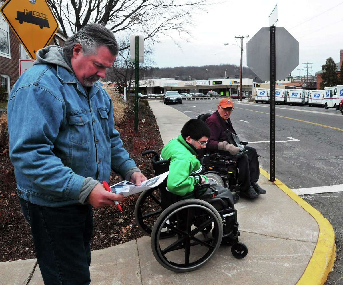 (Mara Lavitt ó New Haven Register) January 20, 2013 Seymour Seymour town engineer Jim Galligan, left, marks where there is no curb cut in downtown Seymour as his son Kevin (of North Branford), center, and Joseph Luciano of Seymour sit nearby.