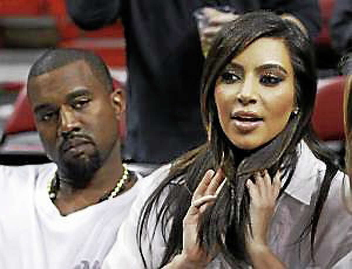 Kim Kardashian, right, and Kanye West, left, are shown before an NBA basketball game between the Miami Heat and the New York Knicks in this Dec, 6, 2012, file photo taken in Miami.