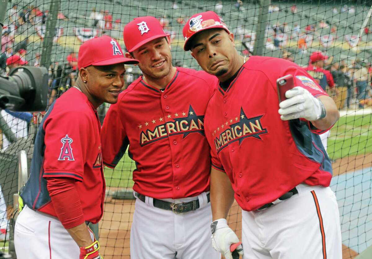 American League's Nelson Cruz, right, of the Baltimore Orioles, takes a photo with fellow American League teammates Ian Kinsler, center, of the Detroit Tigers and Erick Aybar of the Los Angeles Angels during batting practice before the MLB All-Star baseball game, Tuesday, July 15, 2014, in Minneapolis. (AP Photo/Jim Mone)