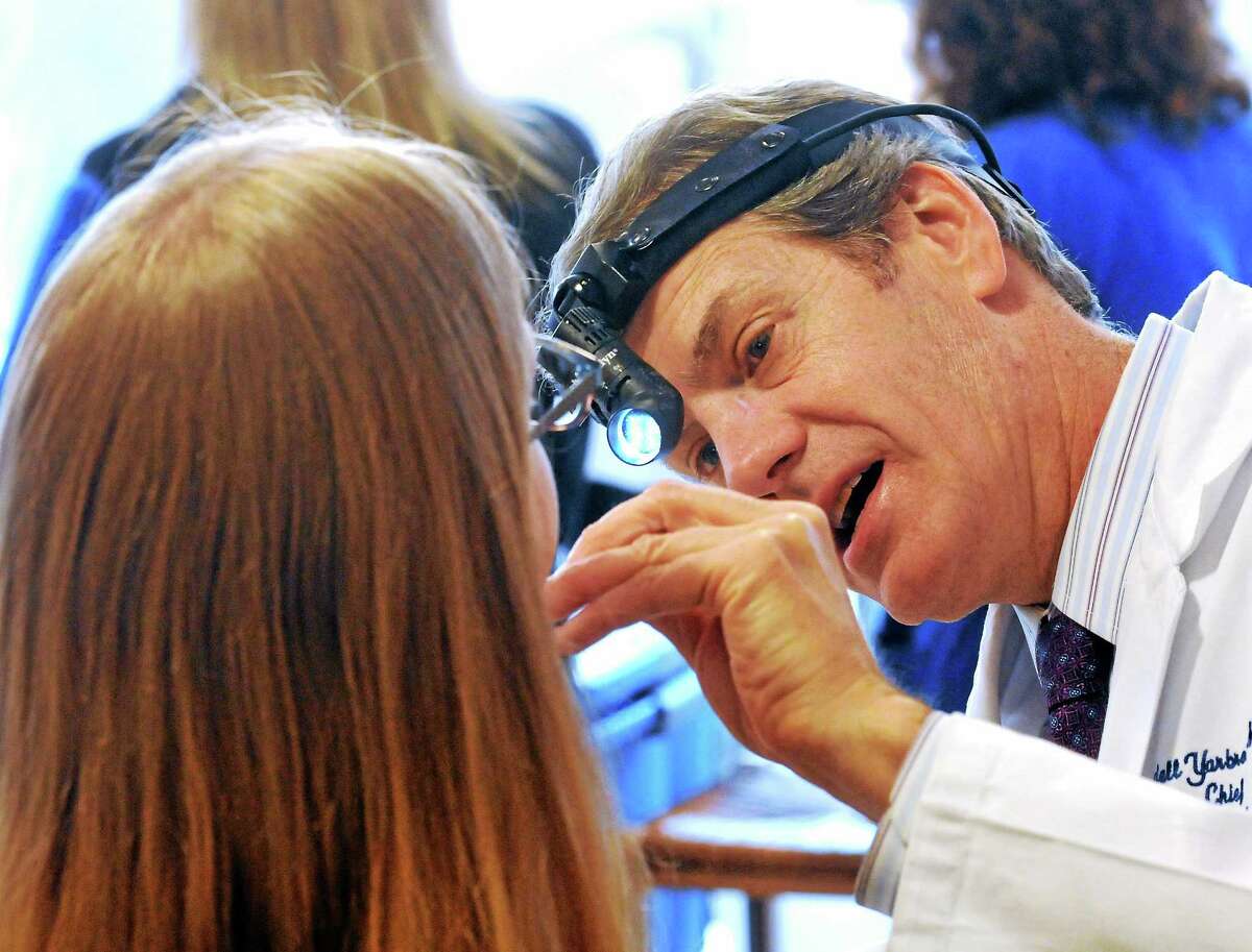 Dr. Wendell Yarbrough, director of the Head & Neck Cancer Program at the Smilow Cancer Hospital, examines Erika Giglio of Meriden during a “Check Up from the Neck Up,” a free head and neck cancer screening held in April at Yale-New Haven Hospital’s two campuses. Several hundred people were screened during the two-day event.