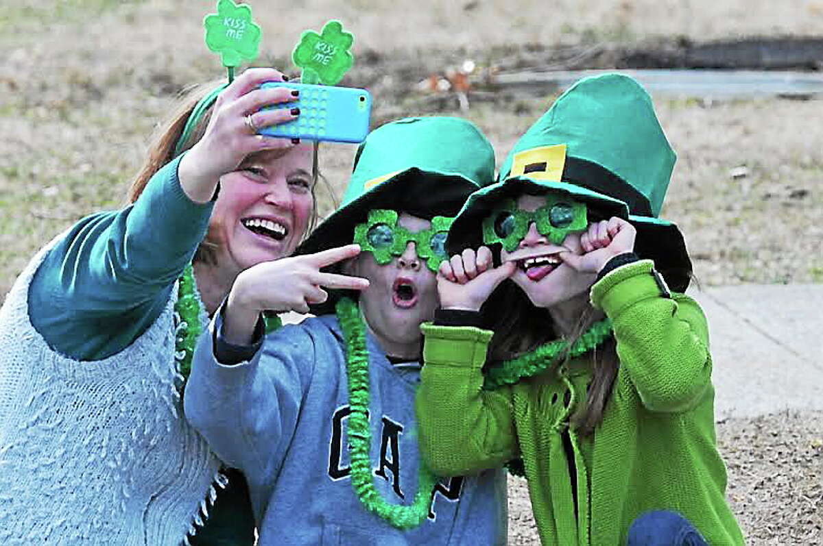 TOP: Shauna Savary of Seymour and her two children — Charlie, 9, and Elizabeth, 7 — take a “selfie” as they wait downtown for the parade to start. Photos by Peter Casolino — New Haven Register