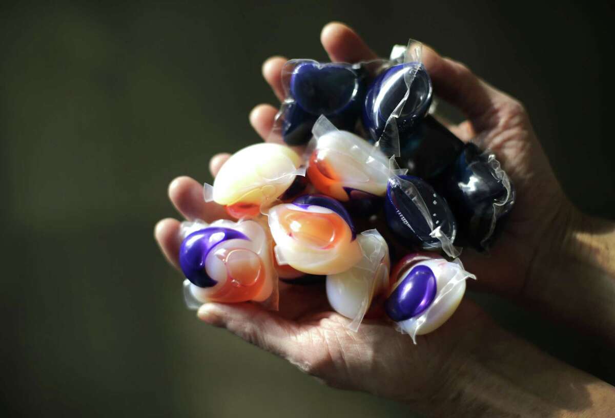 Laundry detergent packets are held for a photo. Accidental poisonings from squishy laundry detergent packets sometimes mistaken for toys or candy landed more than 700 U.S. children in the hospital in just two years, researchers report. Coma and seizures were among the most serious complications.