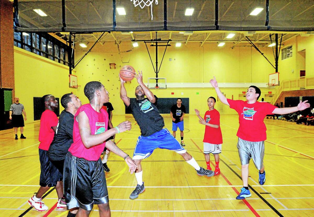 (Arnold Gold-New Haven Register) Gee White, center, puts up a shot in a new basketball league at Ross/Woodward School in New Haven on March 12.