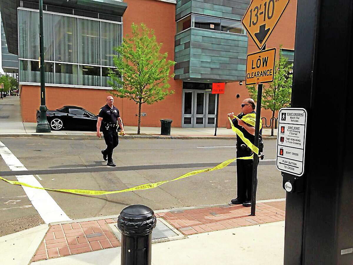 Police officers take down caution tape from an intersection after streets were blocked for the investigation of a suspicious suitcase left near College and George streets. The suitcase was reportedly found to contain clothing.