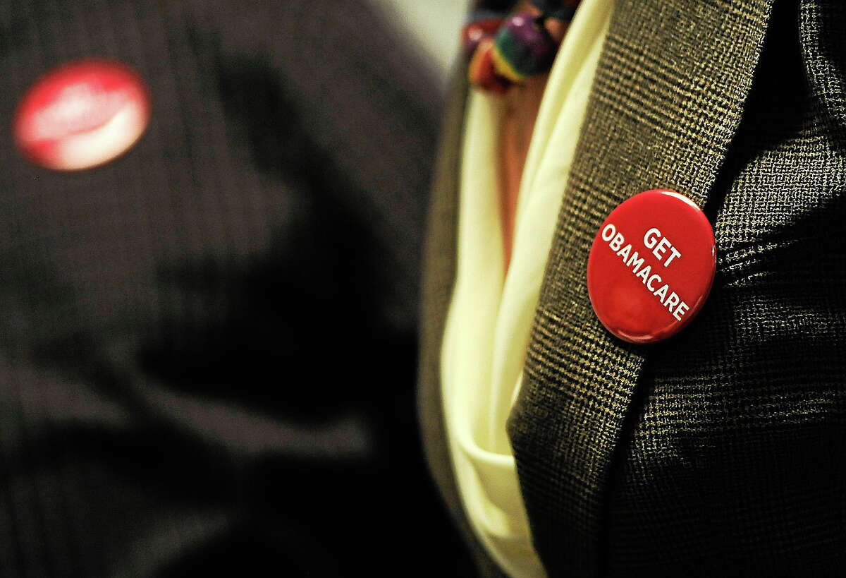 Associates at Community Health Center wear buttons reading “Get Obamacare” during a session to enroll people in the nationís new health insurance system at the Community Health Center, Tuesday, Oct. 1, 2013, in New Britain, Conn.