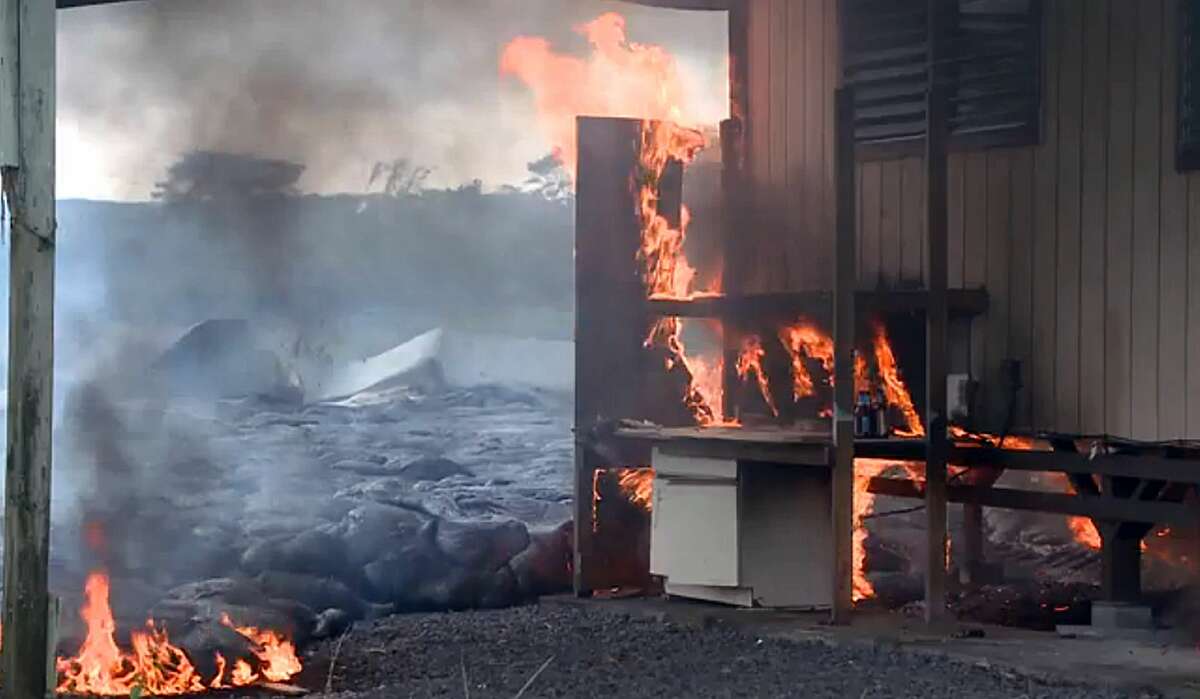 In this image made from video provided by the County of Hawaii, lava flow from the Kilauea Volcano burns a residential structure Monday, Nov. 10, 2014, in Pahoa, Hawaii. A stream of lava set a home on fire Monday in a rural Hawaii town that has been watching the slow-moving flow approach for months.
