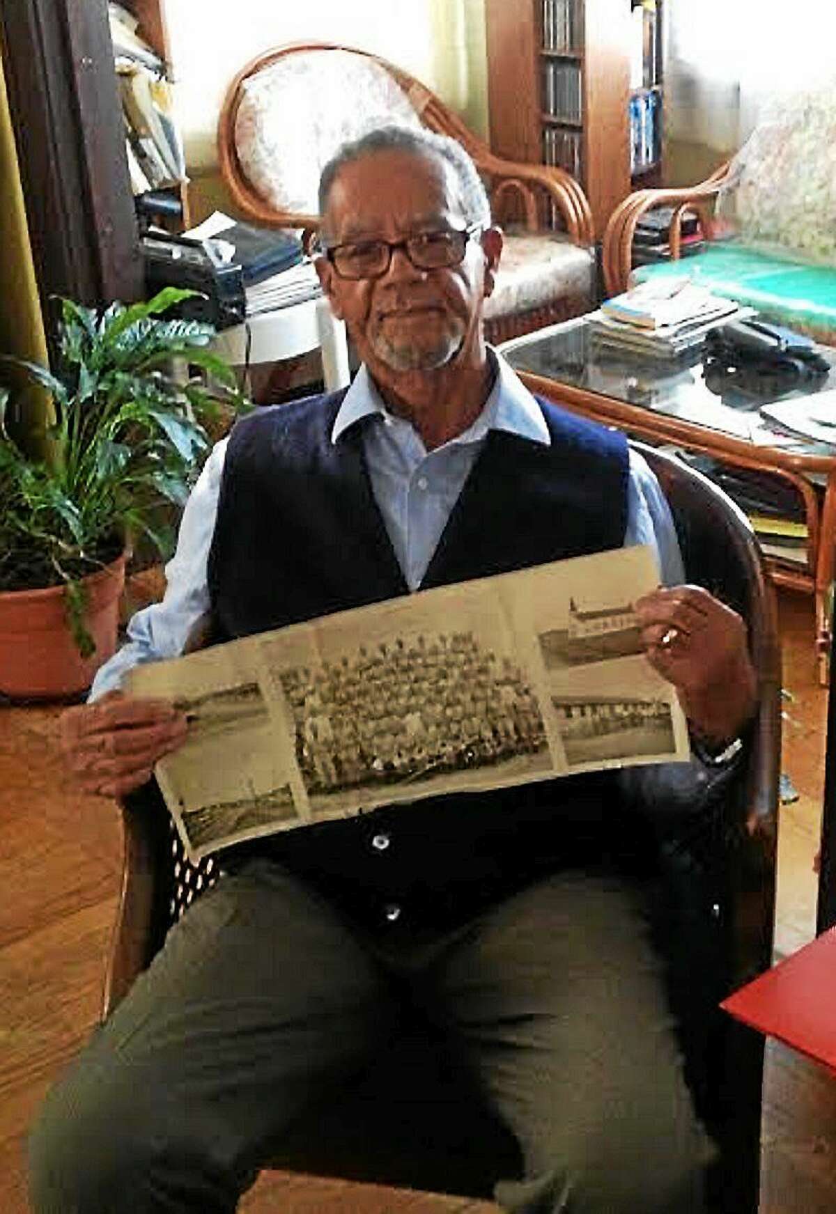 Raymond Sims holding a photo of his 102nd infantry regiment.