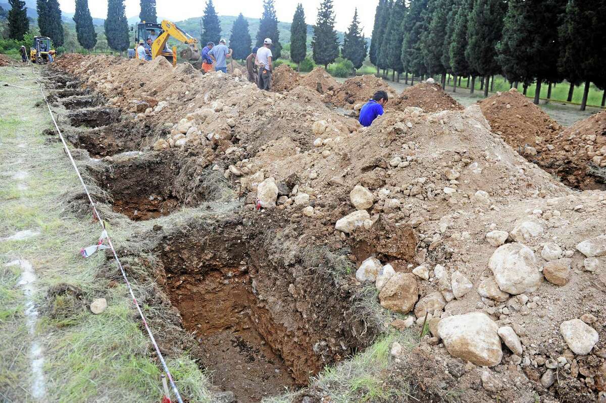 The rows of open tenantless graves are prepared for the mine accident victims in Soma, Turkey, Wednesday, May 14, 2014. Nearly 450 miners were rescued, the mining company said, but the fate of an unknown number of others remained unclear as bodies are still being brought to the surface and burials are underway after one of the world’s deadliest mining disasters.